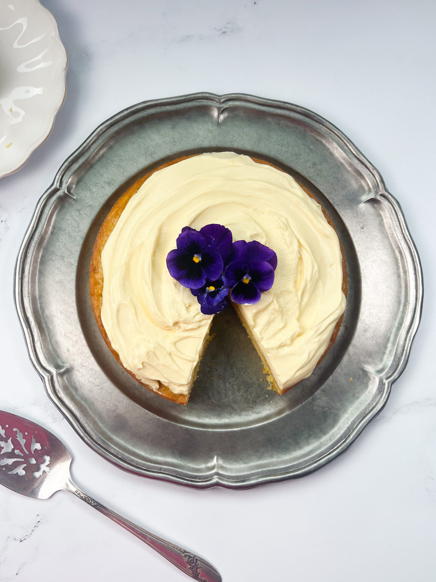 Mango cake with mango mascarpone whipped cream frosting with a slice taken out