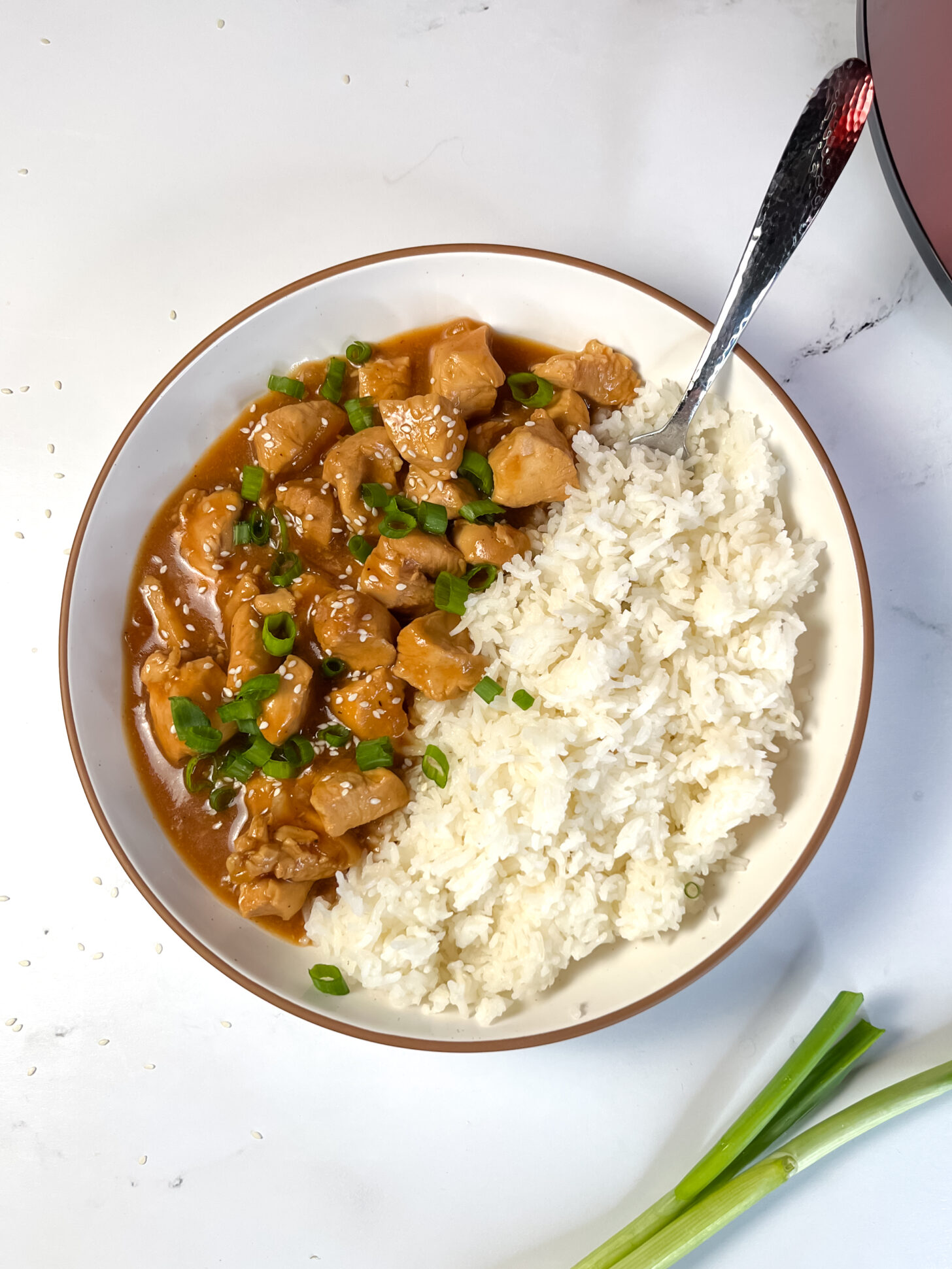 Crock Pot sesame chicken plated in a bowl with white rice