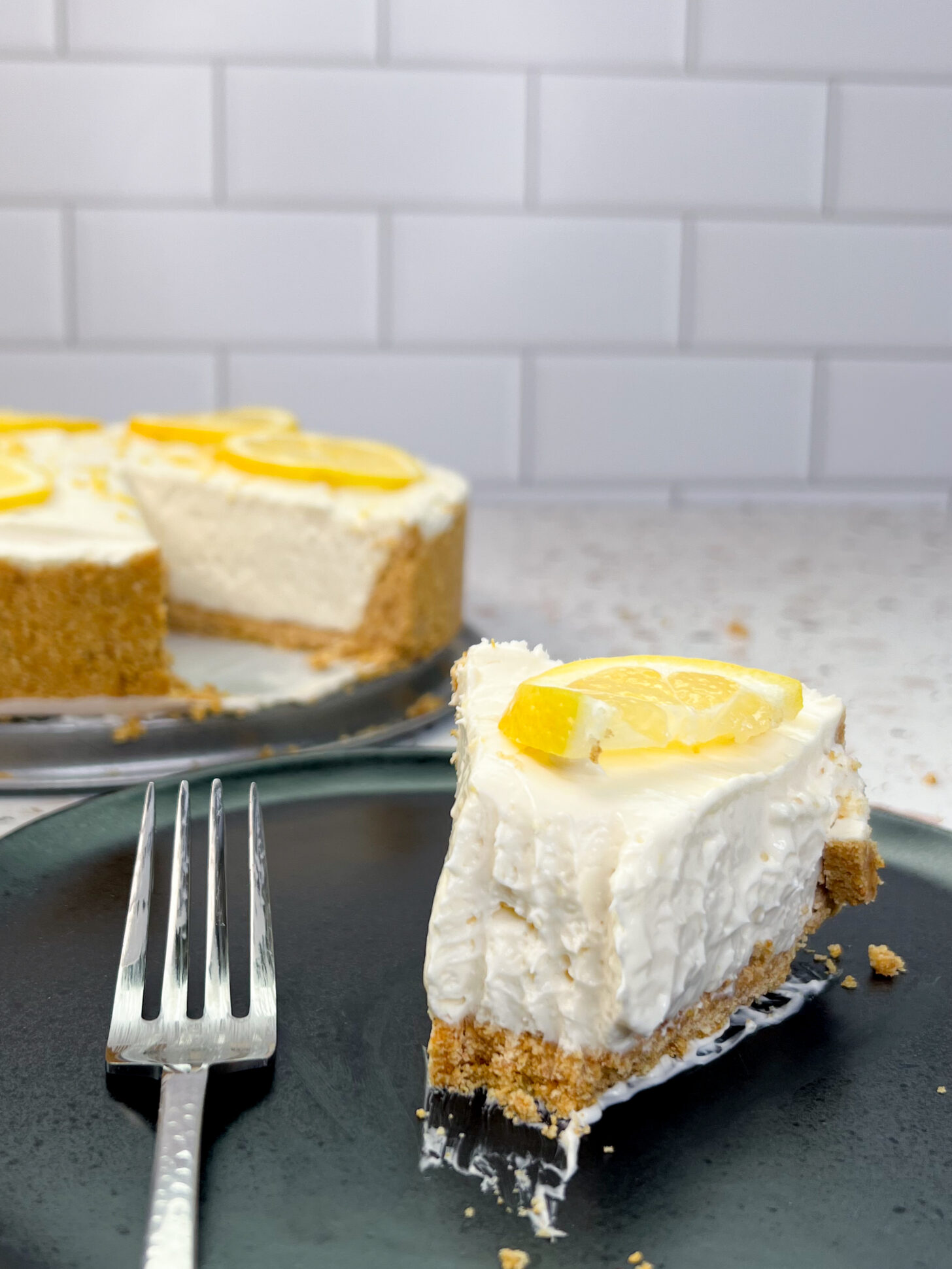 Slice of no bake lemon cheesecake with a bite taken out